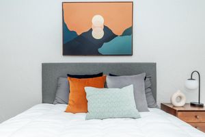 Large painting of a sunset above a bed