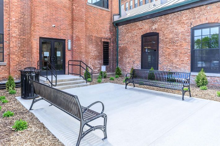 a bench in front of a brick building