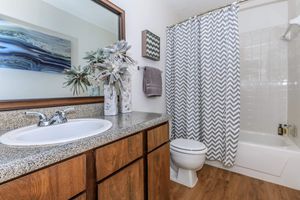 furnished bathroom with wooden cabinets