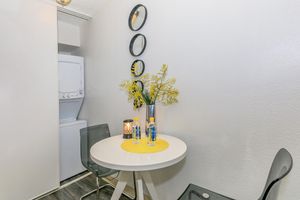 Small sitting and dining area next to a stacked washer and dryer