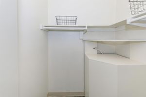 Walk in closet space with built in shelving unit