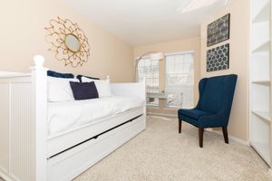 carpeted bedroom with a white comforters