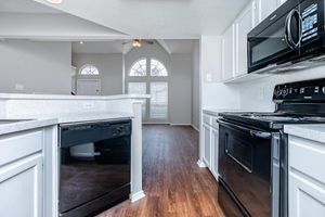 vacant kitchen with white cabinets