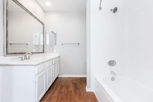 vacant bathroom with white cabinets