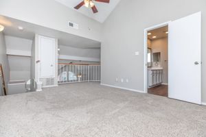 vacant carpeted loft with attached bathroom