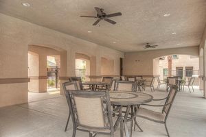 Brown outdoor tables and chairs with a ceiling fan