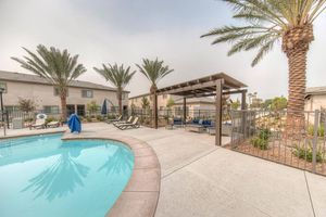 Community pool with blue couches under a pergola