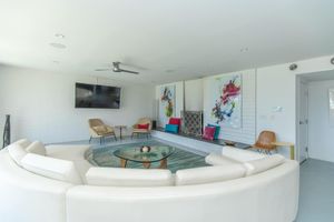 Modern clubhouse with large white couch, wall art decor, and a large flat screen tv