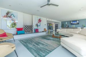 Mid-century modern styled clubhouse room with art and a large white sectional couch
