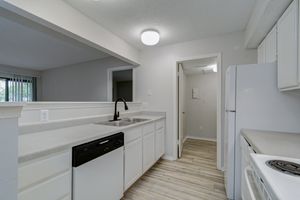 Updated white cabinetry inside kitchen with walk-in pantry at Rainbow Ridge Apartments in Kansas