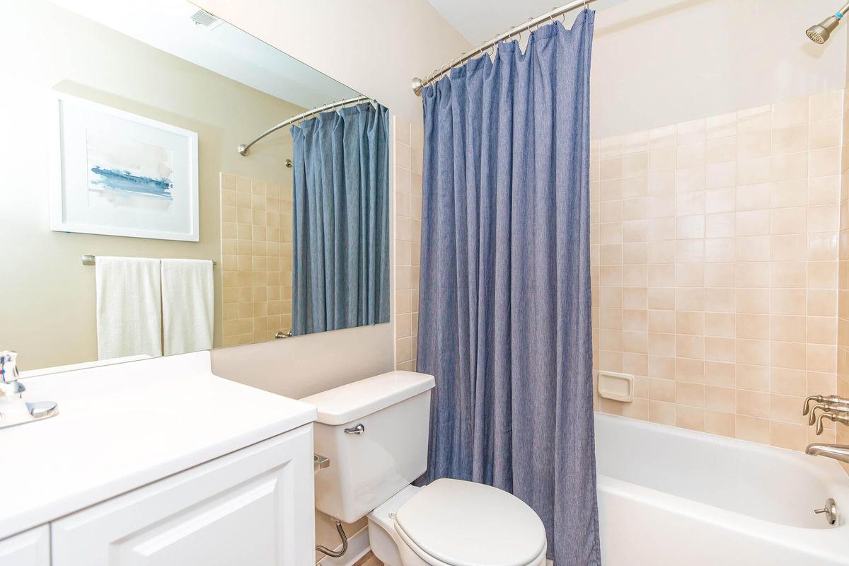 a room with a sink tub and shower curtain