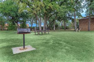barbecue and picnic table with green trees