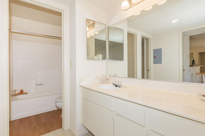a large white tub next to a sink and a mirror