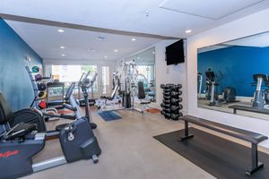 Lakepointe Residence community gym with a mirror