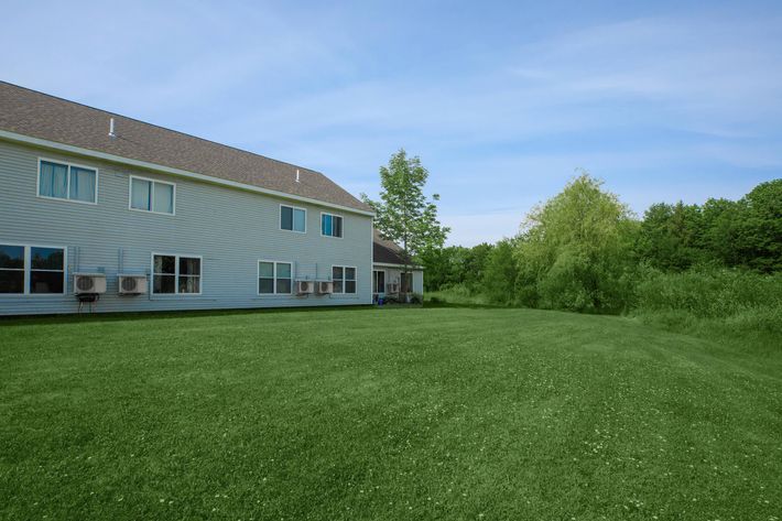 a large green field in front of a house