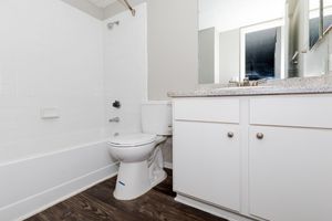vacant bathroom with white cabinets