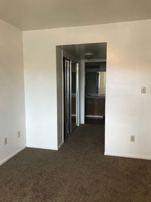 Carpeted bedroom and walkway to bathroom