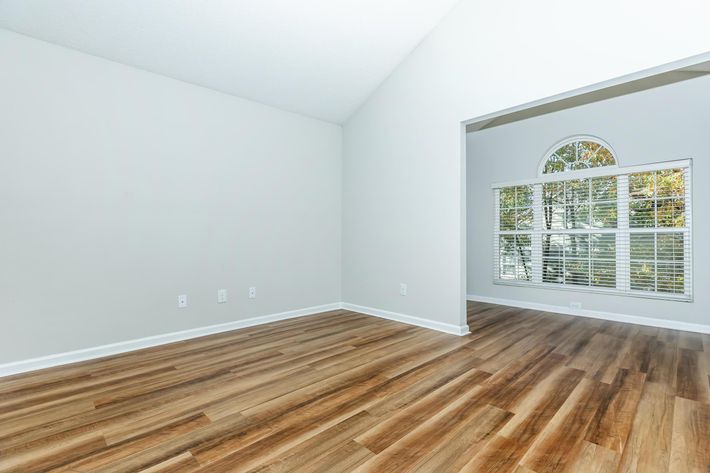 a room with wooden floors and a large window
