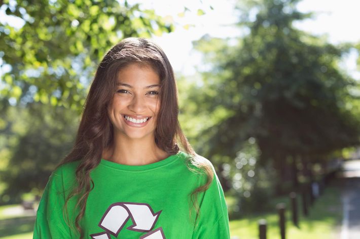 a girl smiling and wearing a green shirt