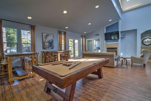 Tan pool table next to tables and chairs