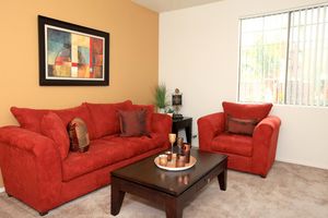 a red leather couch in a living room filled with furniture and a fireplace