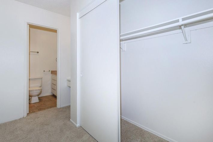 Open sliding closet door with bathroom in the background