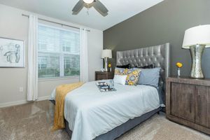 carpeted bedroom with a blue comforter