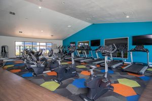 Indoor fitness center facility with workout equipment, and flat screen TVs