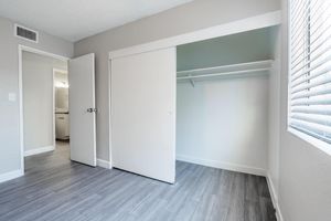 Modern bedroom with wood flooring and sliding door closet