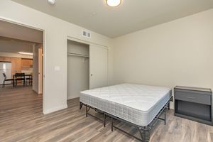 a bedroom with a bed and desk in a room