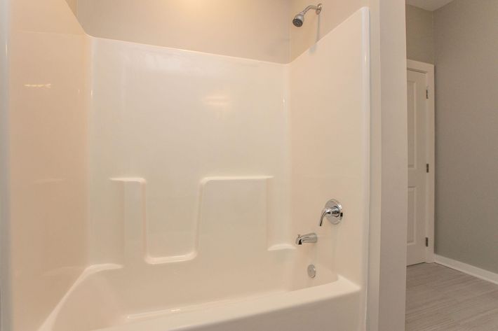 a close up of a white tub sitting next to a shower
