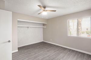 Spacious main bedroom with large window, ceiling fan, an built in closet space