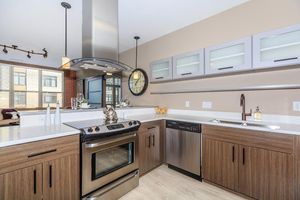 a kitchen with a clock at the top of a wooden counter