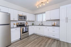 Large modern renovated kitchen with white cabinets and stainless steel appliances
