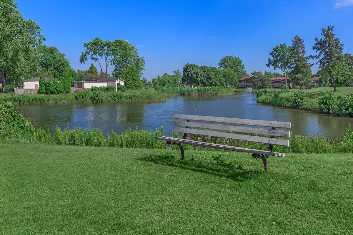 a row of park benches sitting next to a body of water