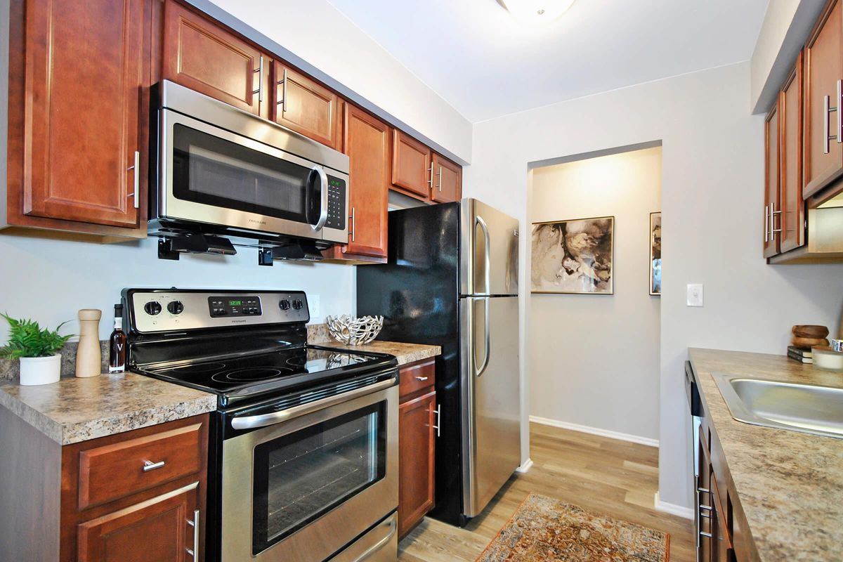 a stove top oven sitting inside of a kitchen with stainless steel appliances