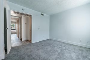 Large spacious main bedroom with grey carpet and white walls