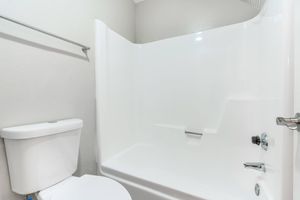 Close up view of a white shower tub and toilet