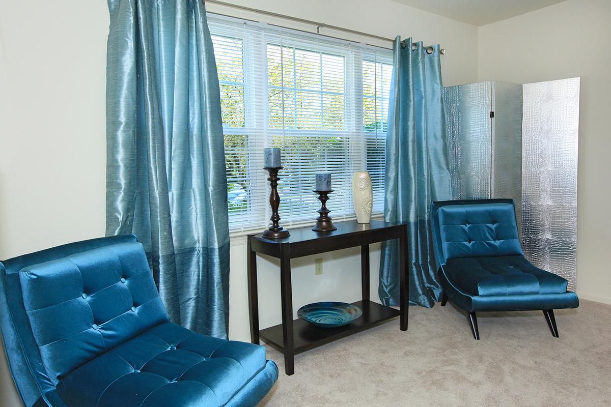 a bedroom with a blue chair in a room