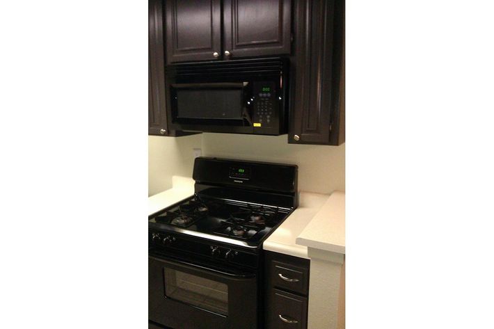 a black stove top oven sitting inside of a kitchen