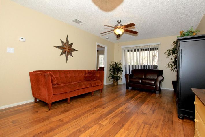 a living room filled with furniture on top of a hard wood floor