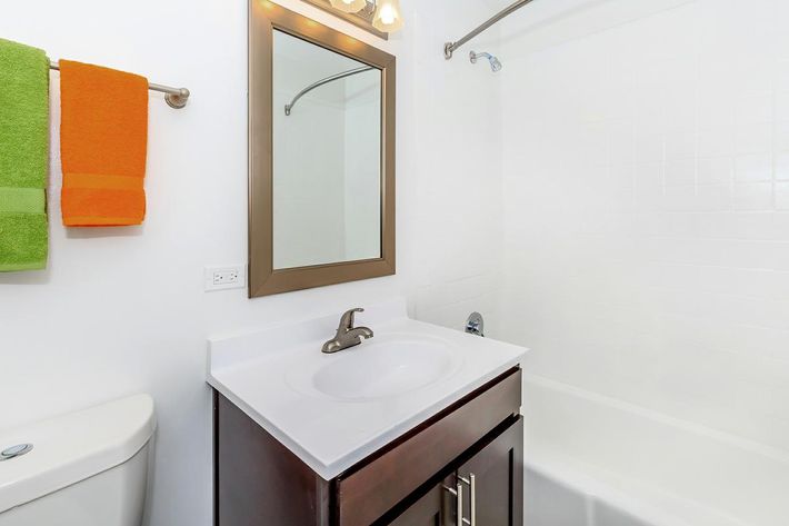 a white sink sitting under a mirror