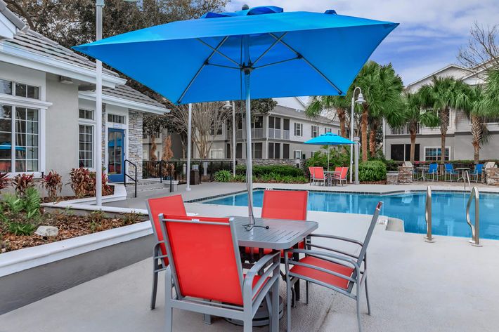 a blue umbrella sitting on a chair in front of a house