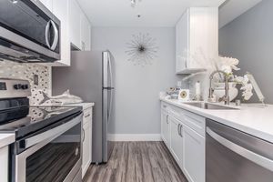 a kitchen with a stove a sink and a mirror