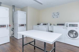 a kitchen with a refrigerator and table in a room