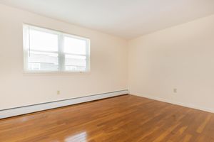 Unfurnished bedroom with wooden floors