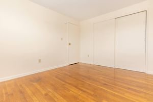 Unfurnished bedroom with closed sliding closet doors