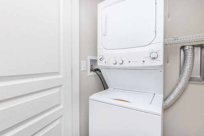 a white microwave oven sitting on top of a refrigerator
