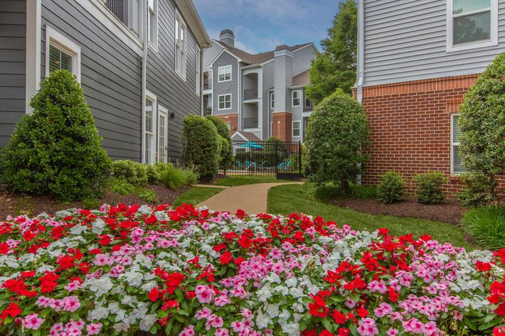 a colorful flower garden in front of a brick building