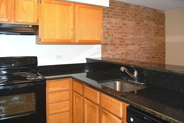 a kitchen with wooden cabinets and a black stove top oven